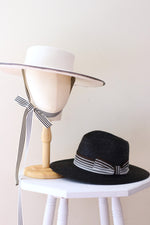 Cargar imagen en el visor de la galería, Grosgrain white wool felt wide-brimmed boater  with chin strap ribbons and black straw fedora hat
