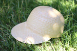 Load image into Gallery viewer, Grosgrain natural straw cap on grass
